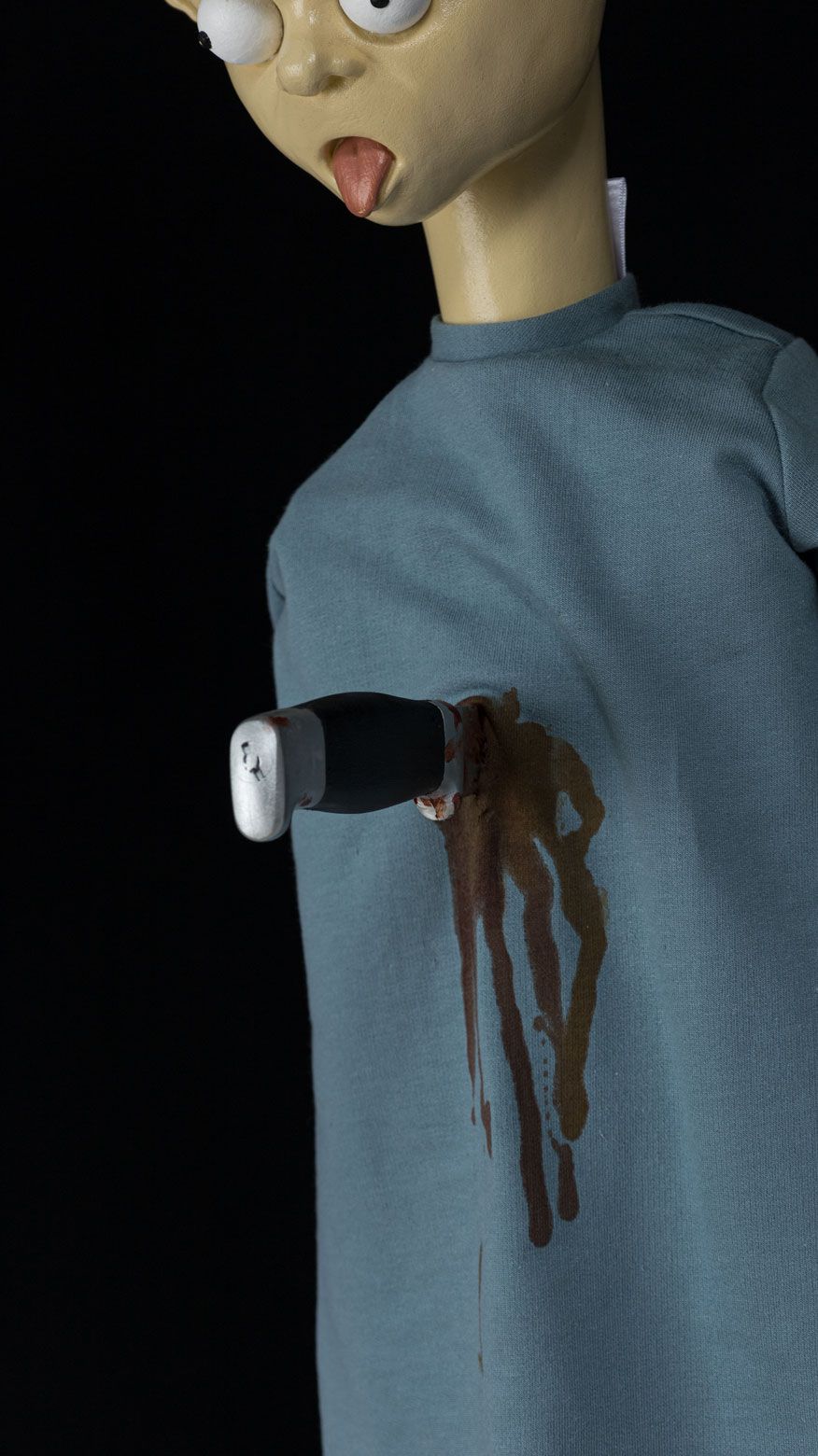 Detalje af kniv og blod pÃ¥ blÃ¥ kjole i skulpturen Stay Unlucky.